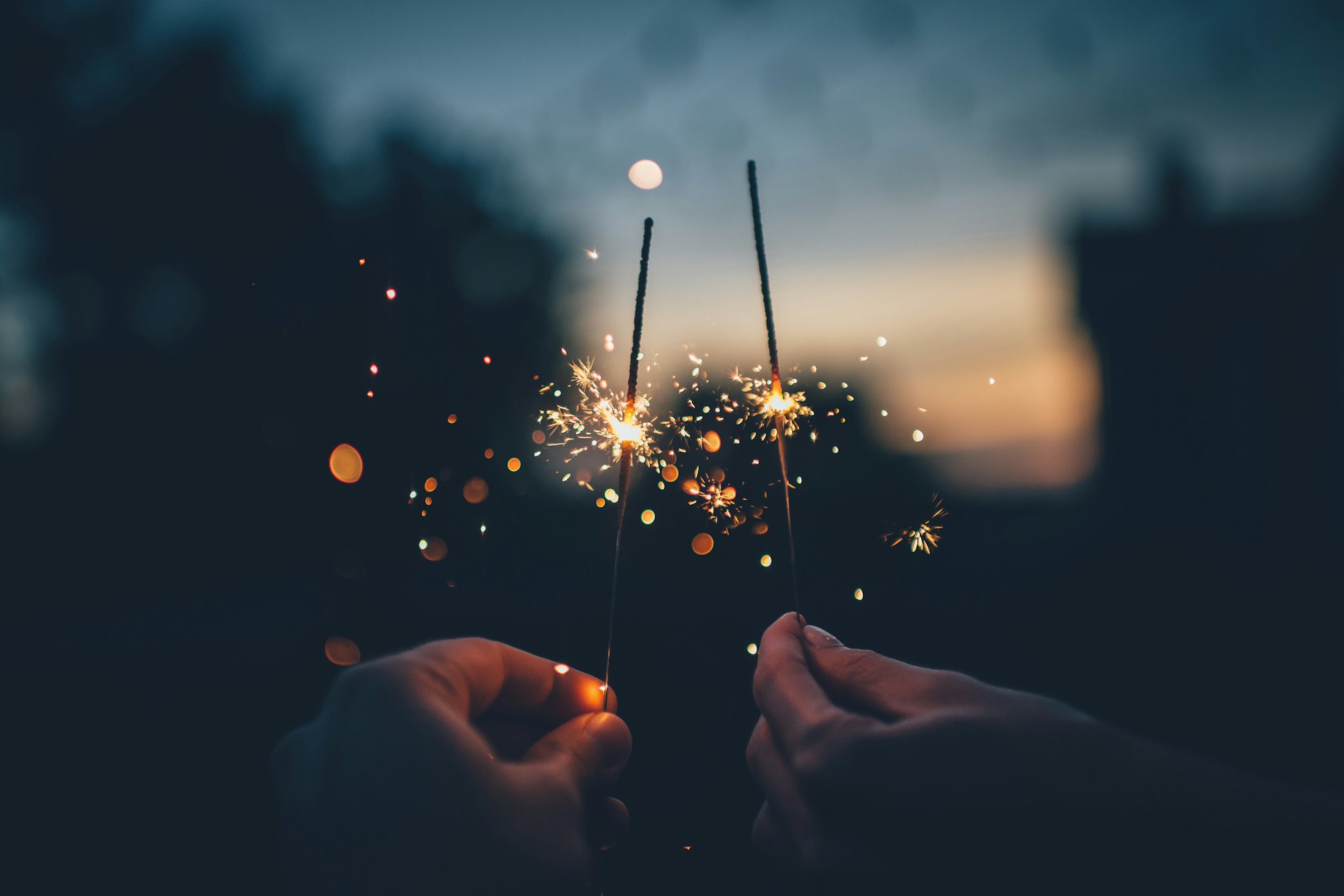 Friends holding sparklers at a night celebration