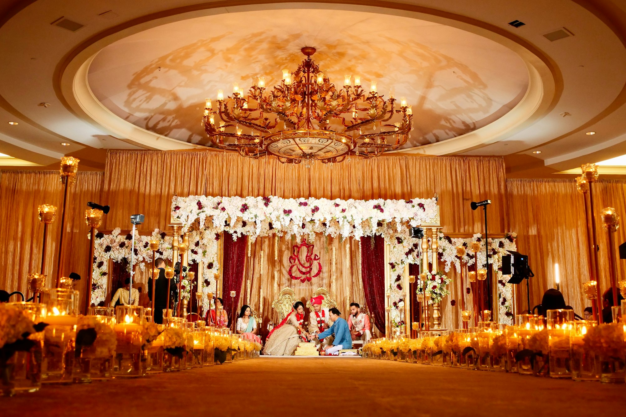A grand Indian wedding stage lit in warm gold