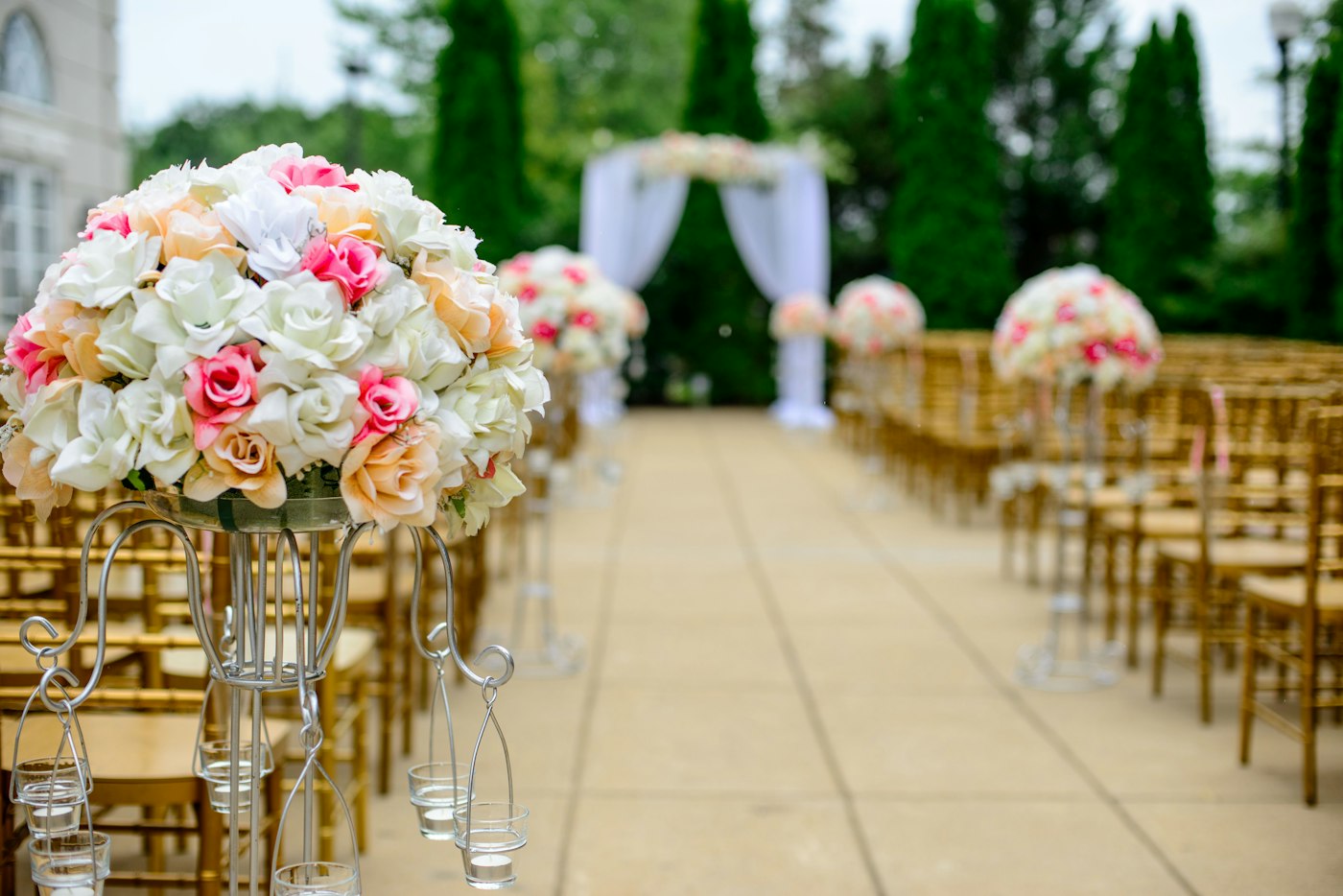A floral wedding aisle lined with gold chairs